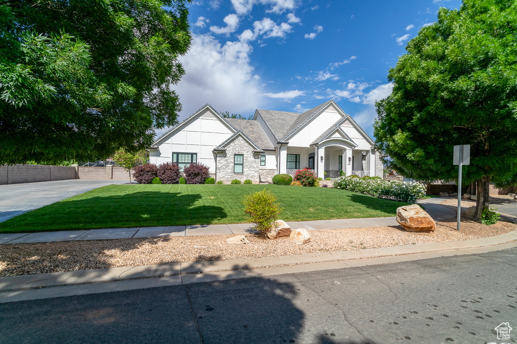 View of front of home featuring a front yard and stone siding