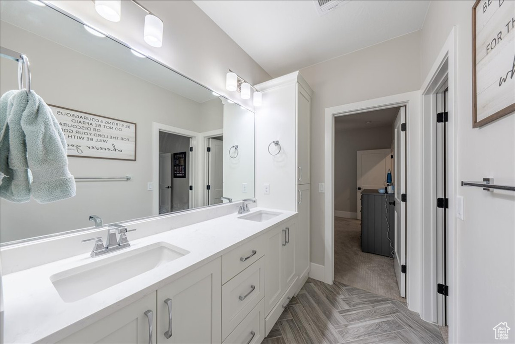 Full bathroom with double vanity and baseboards