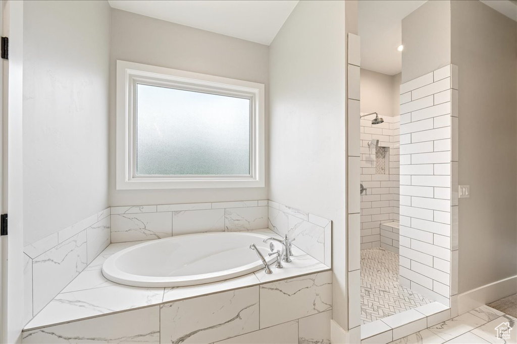 Full bathroom with tiled shower, a bath, marble finish floors, and baseboards