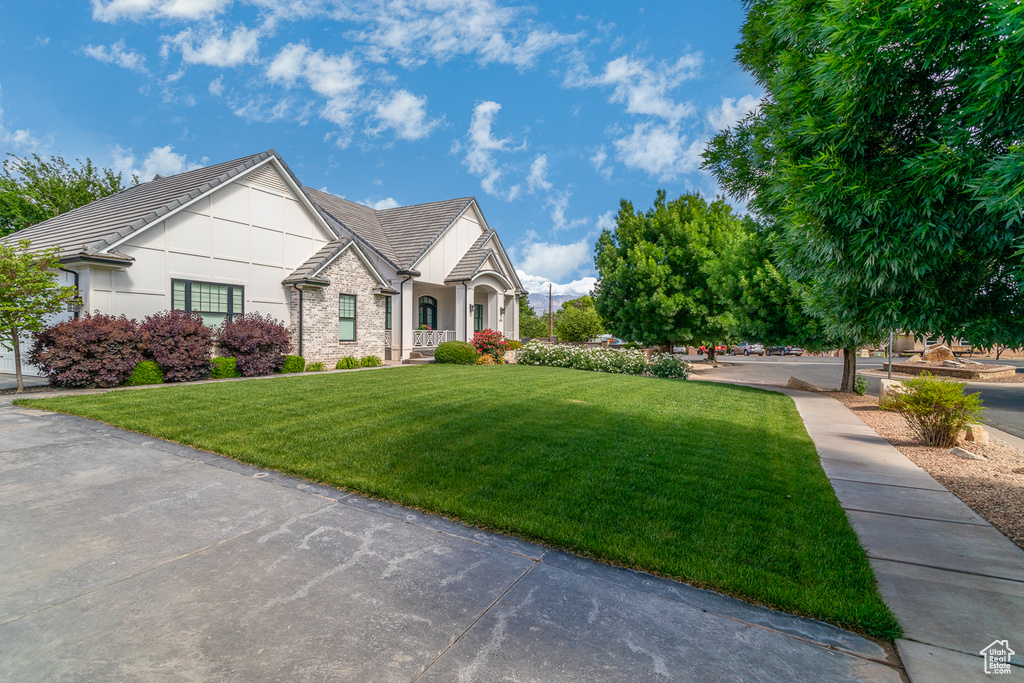 View of front facade with a front yard and stucco siding