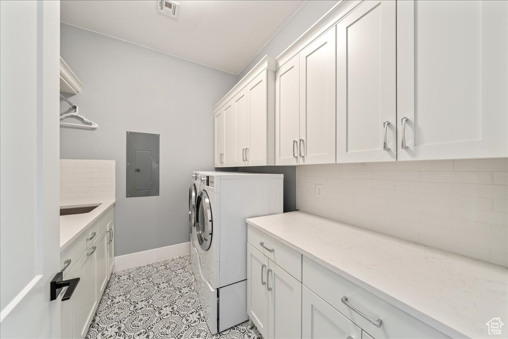Laundry room with electric panel, cabinet space, baseboards, independent washer and dryer, and light tile patterned flooring