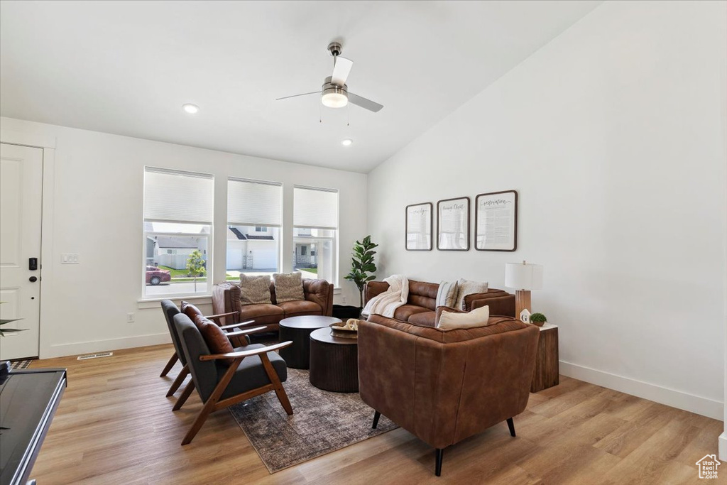 Living area with a ceiling fan, light wood-style flooring, baseboards, lofted ceiling, and recessed lighting
