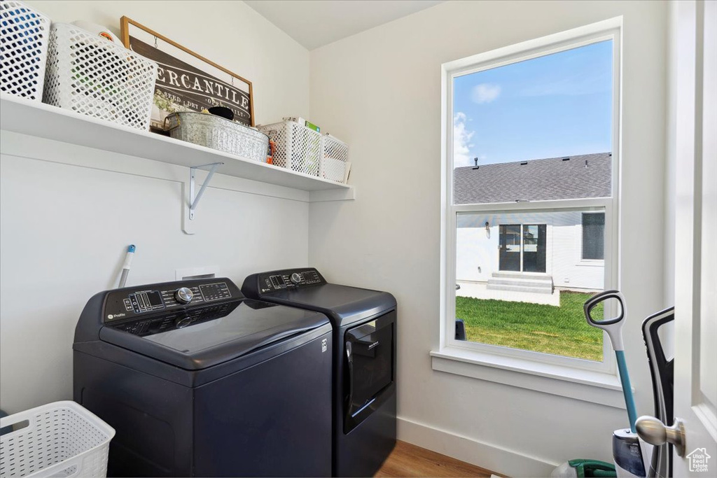 Washroom with separate washer and dryer, baseboards, and wood finished floors