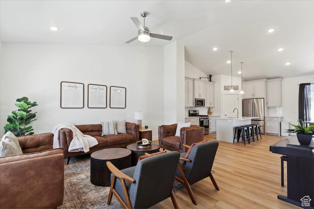Living area featuring ceiling fan, light wood finished floors, recessed lighting, and high vaulted ceiling