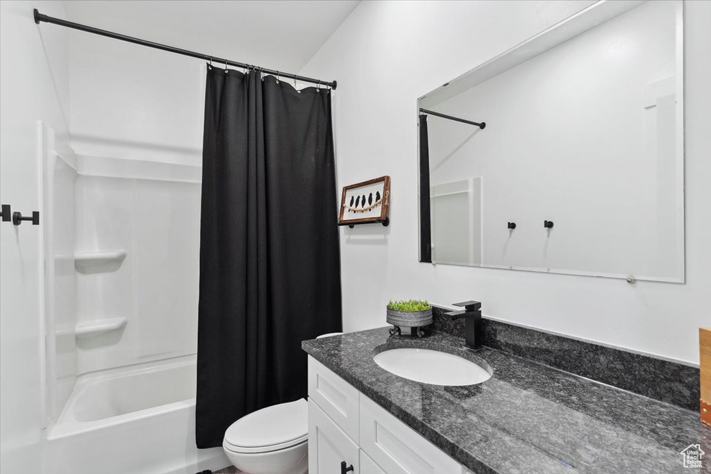 Full bath with vanity, toilet, and shower / bathtub combination with curtain