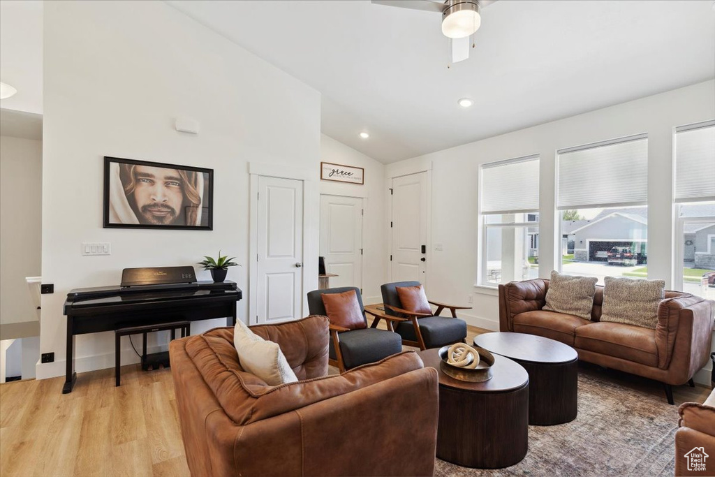 Living room with vaulted ceiling, light wood finished floors, plenty of natural light, ceiling fan, and recessed lighting