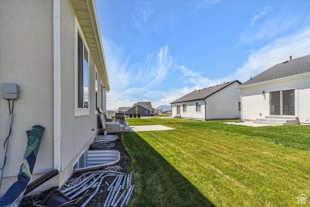 View of grassy yard featuring entry steps