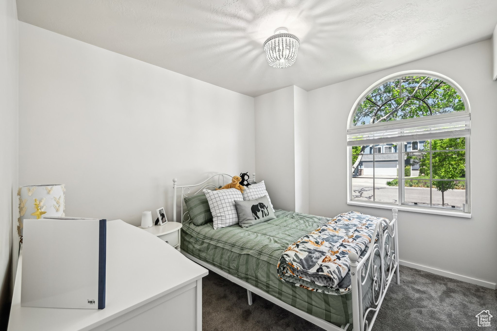 Bedroom with carpet flooring, a chandelier, and baseboards