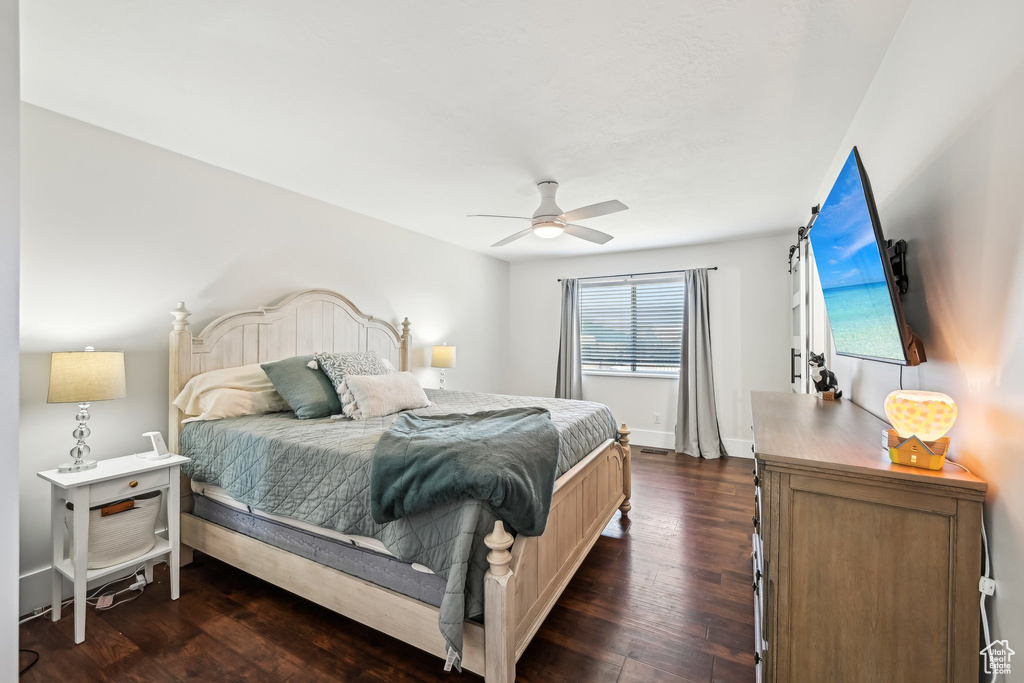 Bedroom with dark wood-type flooring and a ceiling fan