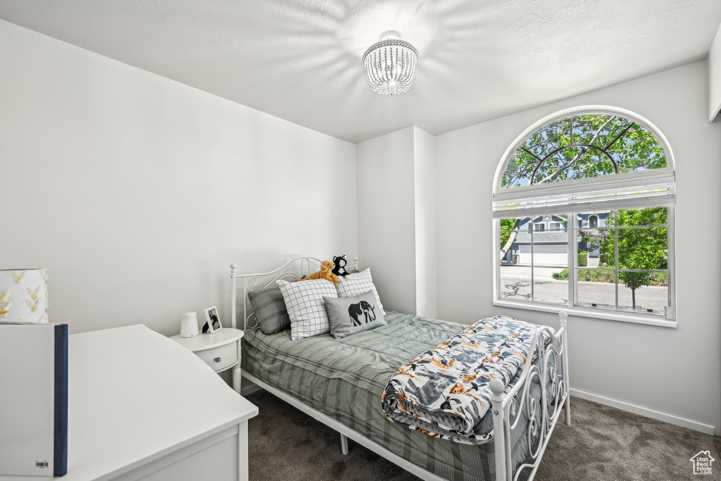 Bedroom with carpet floors, a chandelier, and baseboards