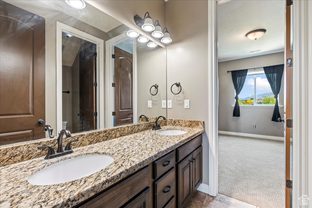 Full bath featuring baseboards and double vanity