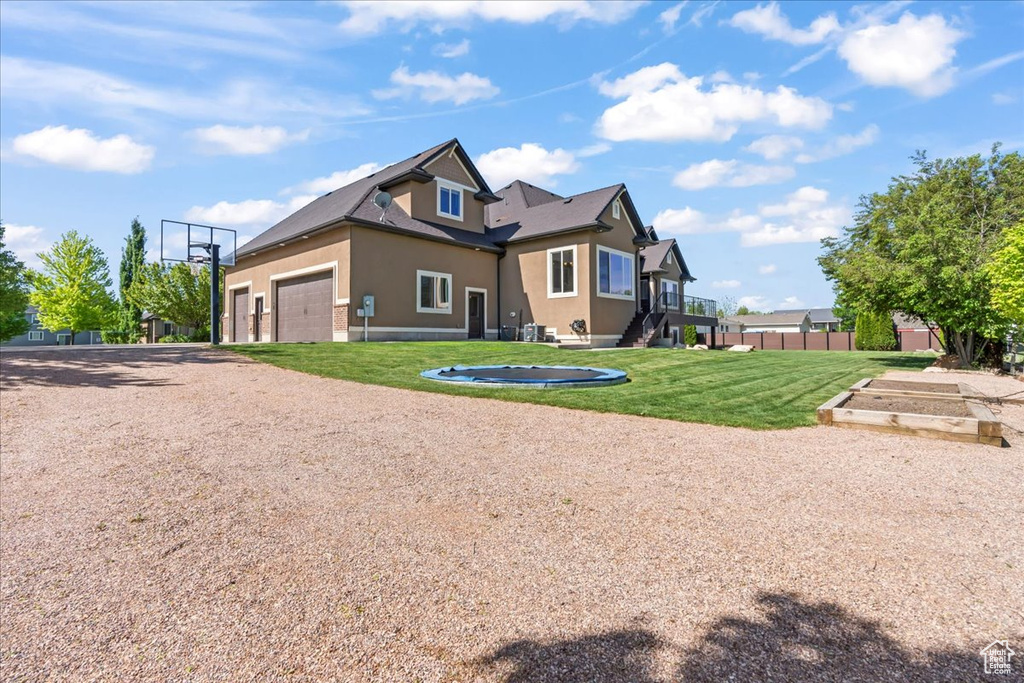 View of side of property featuring stucco siding, a vegetable garden, and driveway