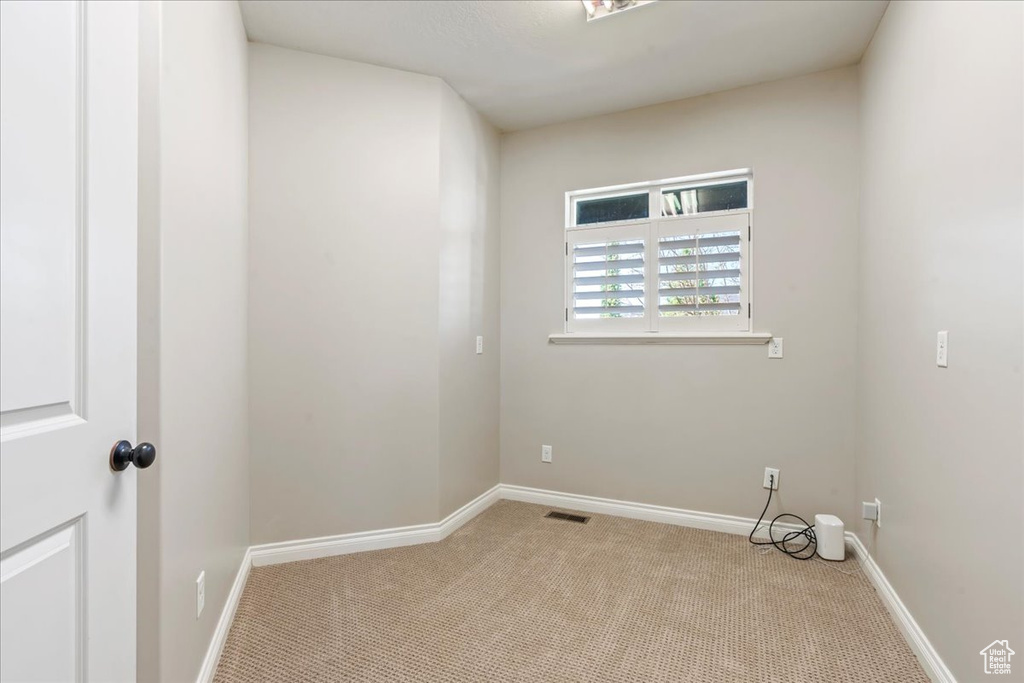 Spare room with light carpet and baseboards