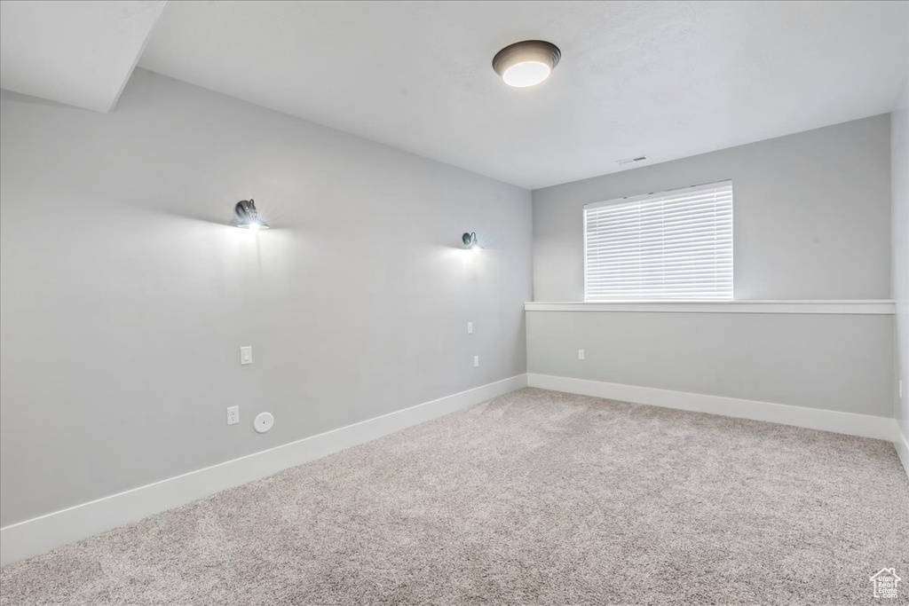 Carpeted empty room featuring baseboards