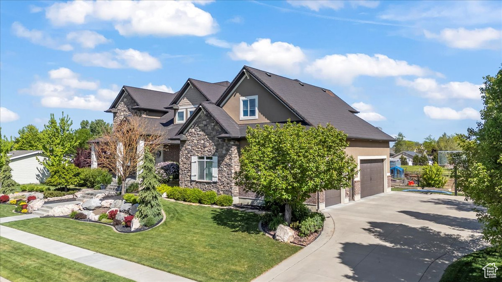 Craftsman house with stone siding, driveway, stucco siding, and a garage