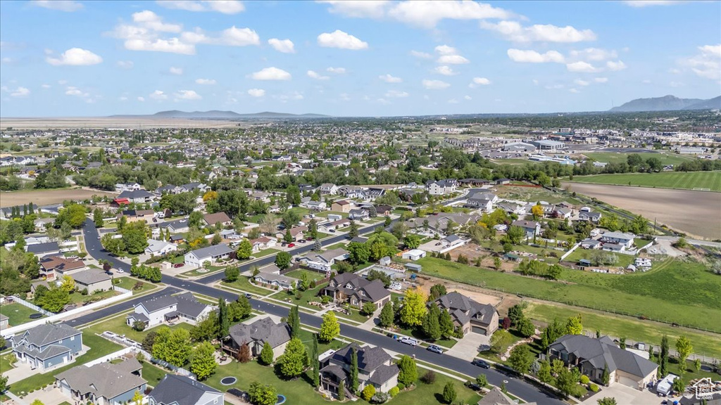Aerial view of property and surrounding area featuring a mountainous background and nearby suburban area