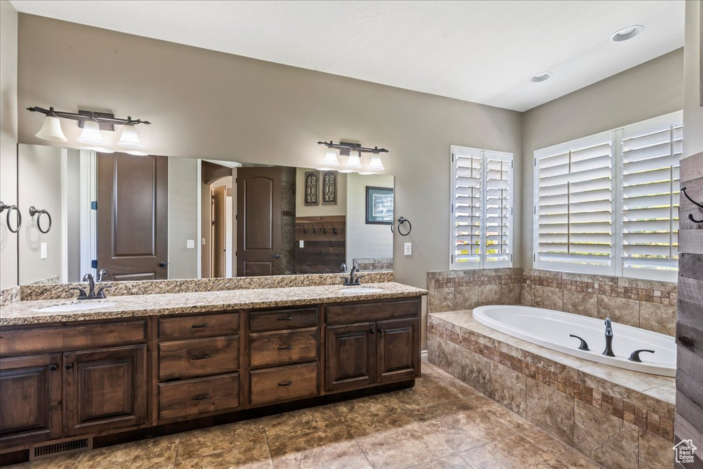 Bathroom featuring a garden tub and double vanity