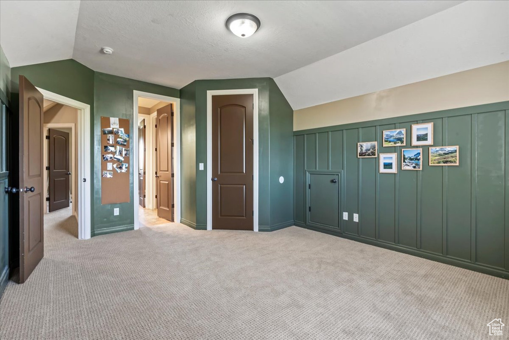Additional living space with lofted ceiling and carpet floors