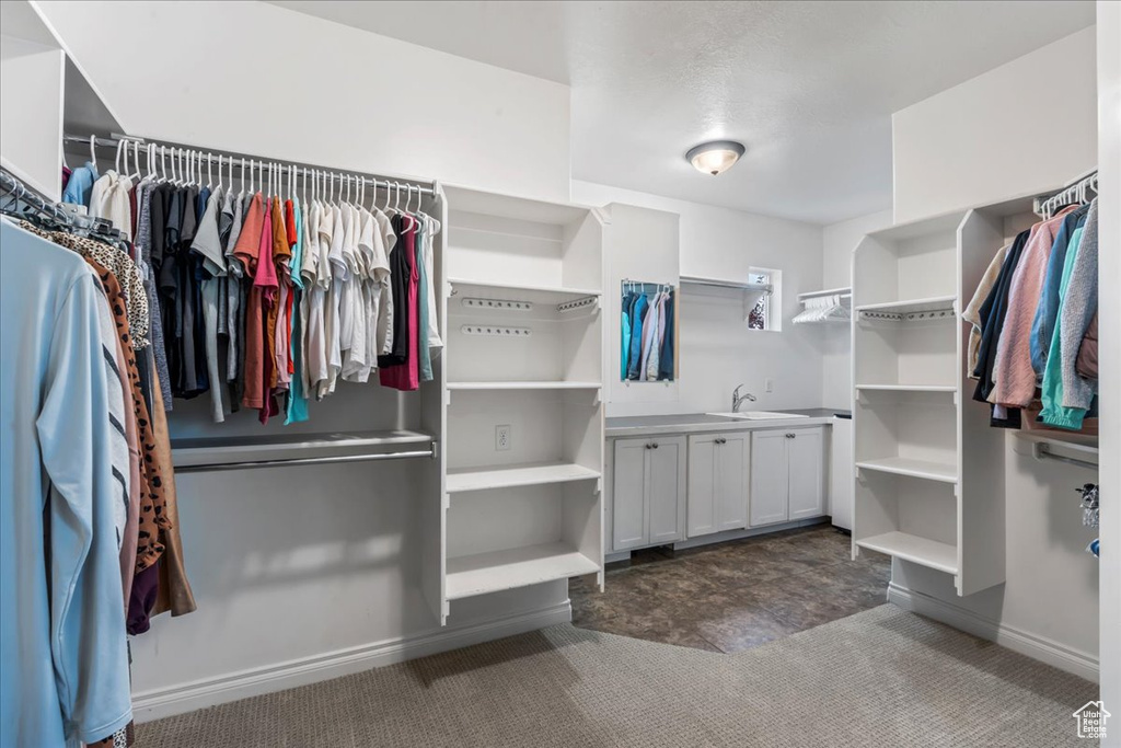 Spacious closet featuring carpet floors and a sink