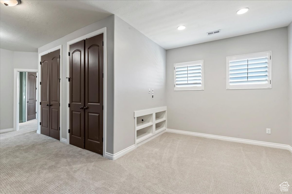 Carpeted spare room with baseboards and recessed lighting