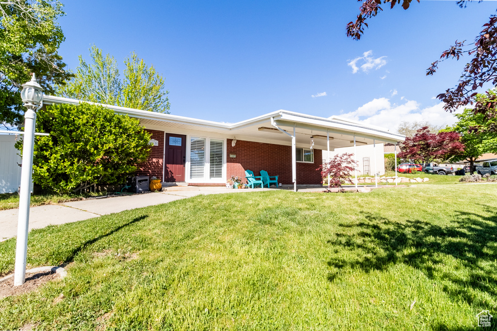 Single story home with brick siding and a front yard