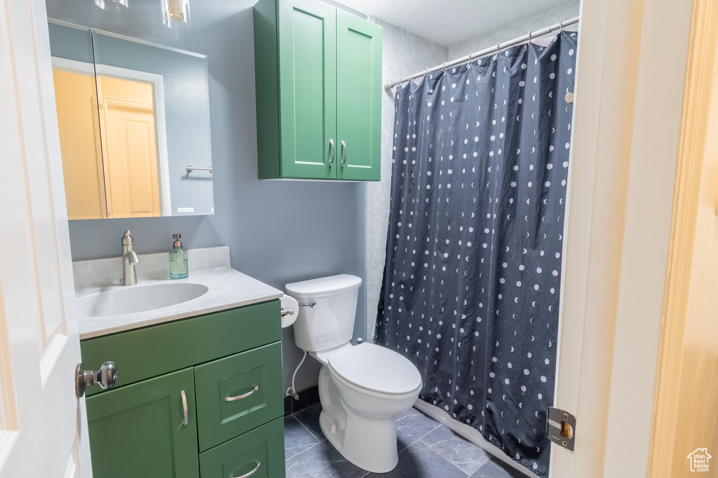Bathroom with tile patterned flooring, toilet, vanity, and a shower with curtain