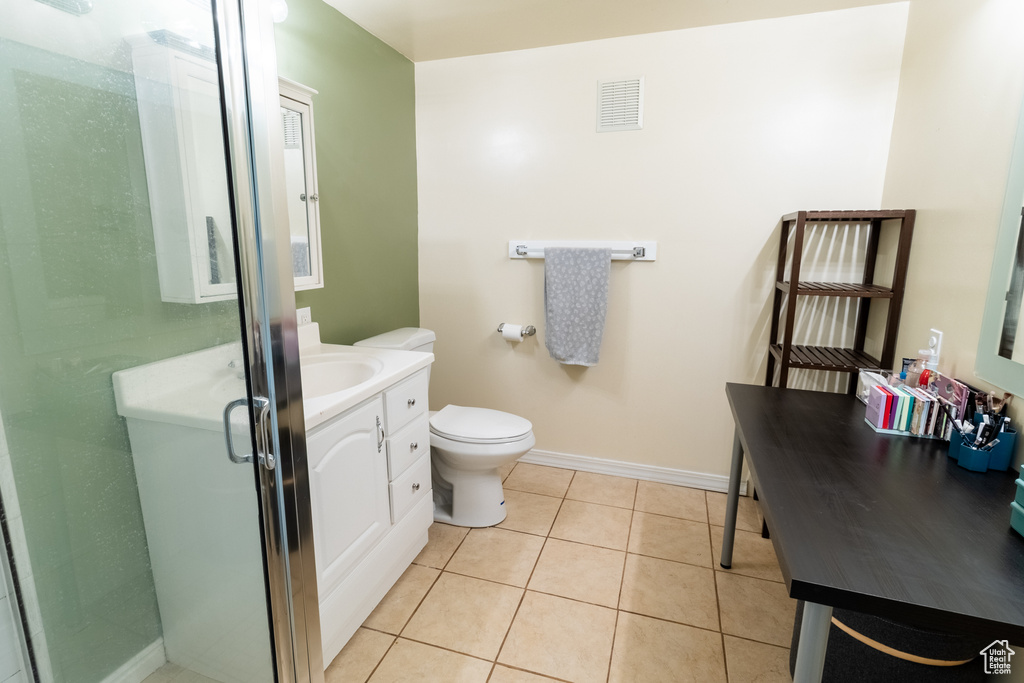 Bathroom featuring vanity, tile patterned floors, a stall shower, toilet, and baseboards