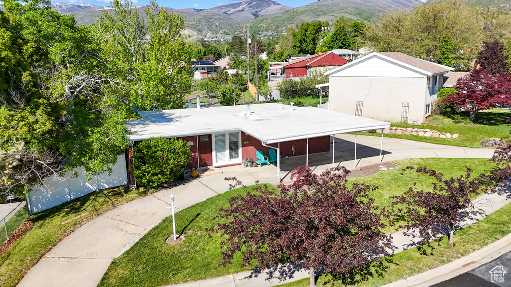 View of front of property with brick siding, a mountain view, and a front yard