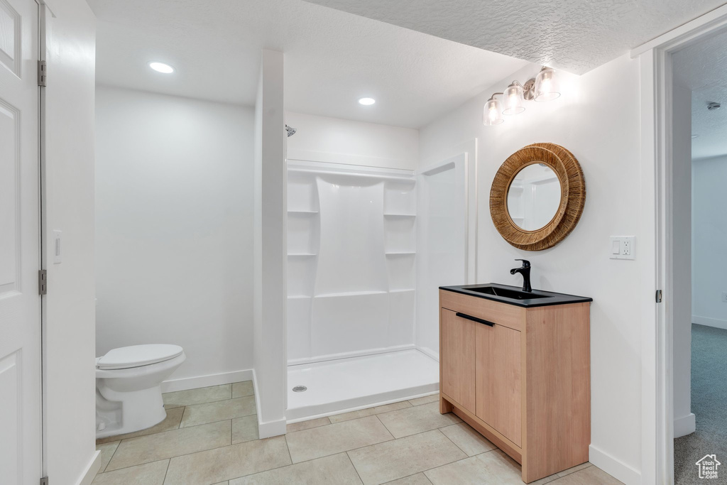 Full bath with toilet, a walk in shower, baseboards, vanity, and recessed lighting