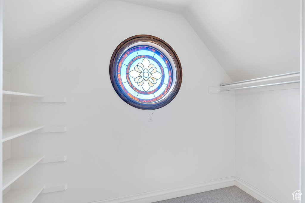 Spacious closet with lofted ceiling and carpet