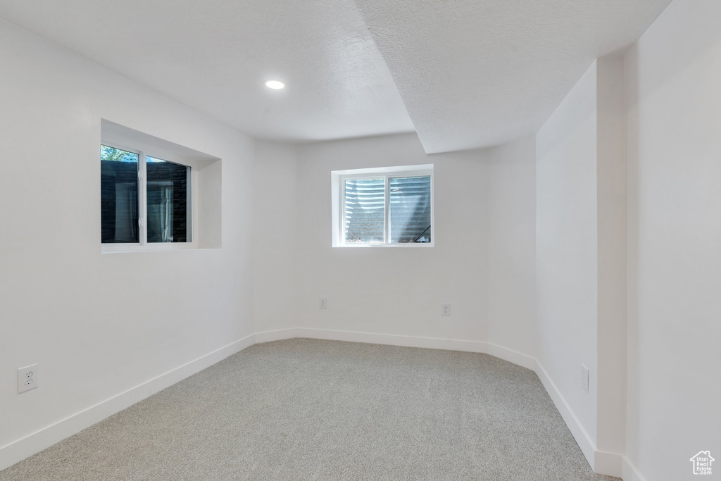 Carpeted empty room featuring baseboards, healthy amount of natural light, and recessed lighting