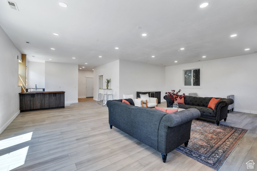 Living room with recessed lighting, light wood-type flooring, and baseboards