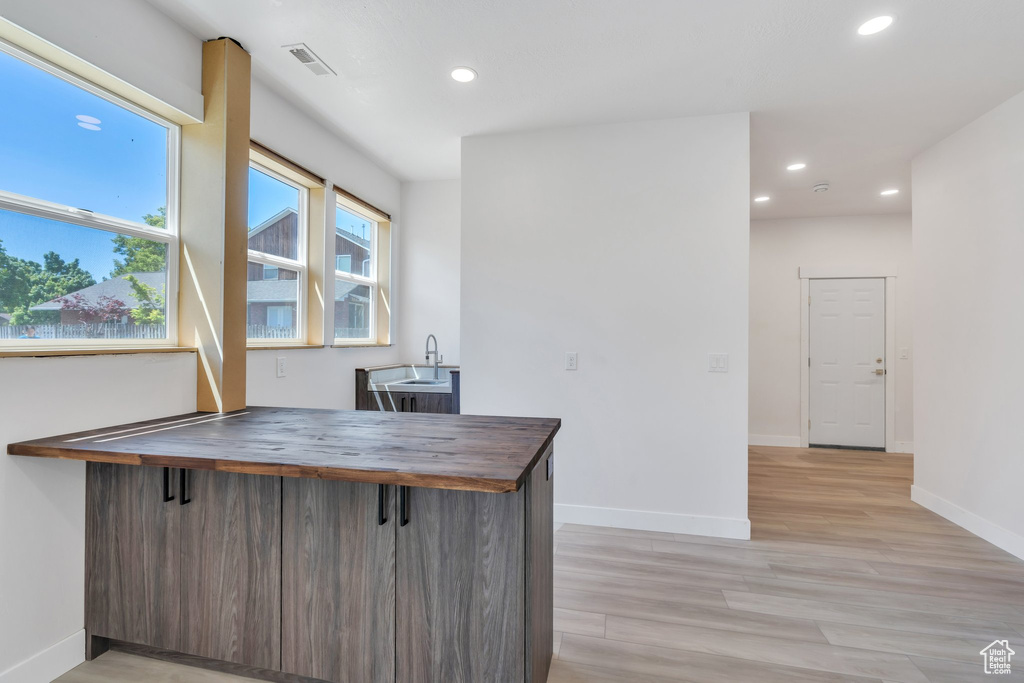 Office with recessed lighting, baseboards, light wood-type flooring, and a sink