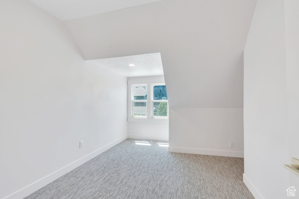 Additional living space with baseboards, carpet, and vaulted ceiling