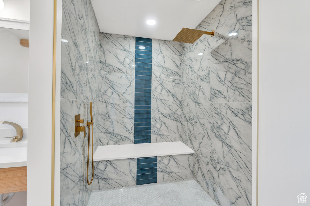 Full bath featuring a marble finish shower, vanity, and recessed lighting