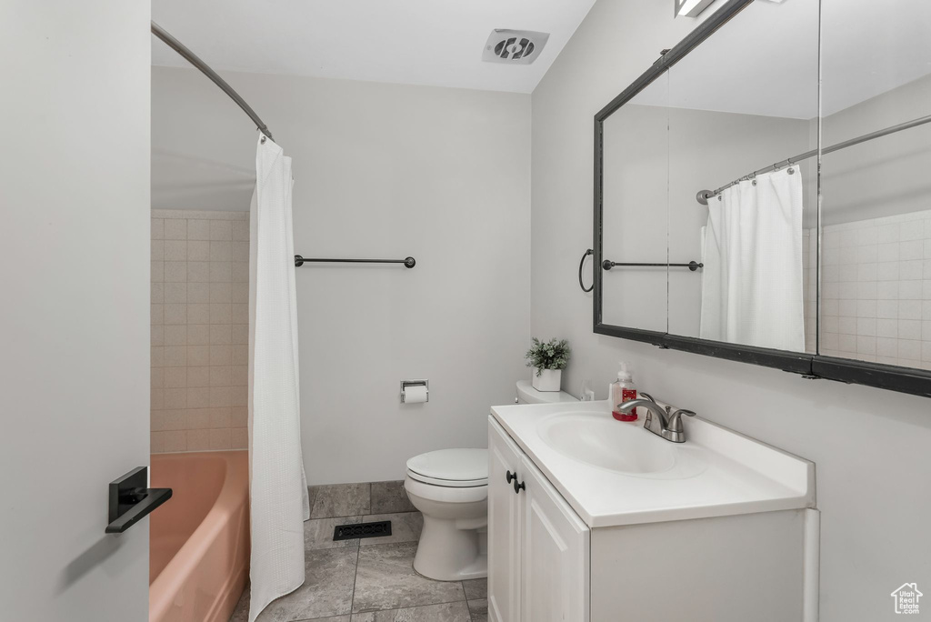 Full bathroom featuring toilet, vanity, and shower / bath combo with shower curtain
