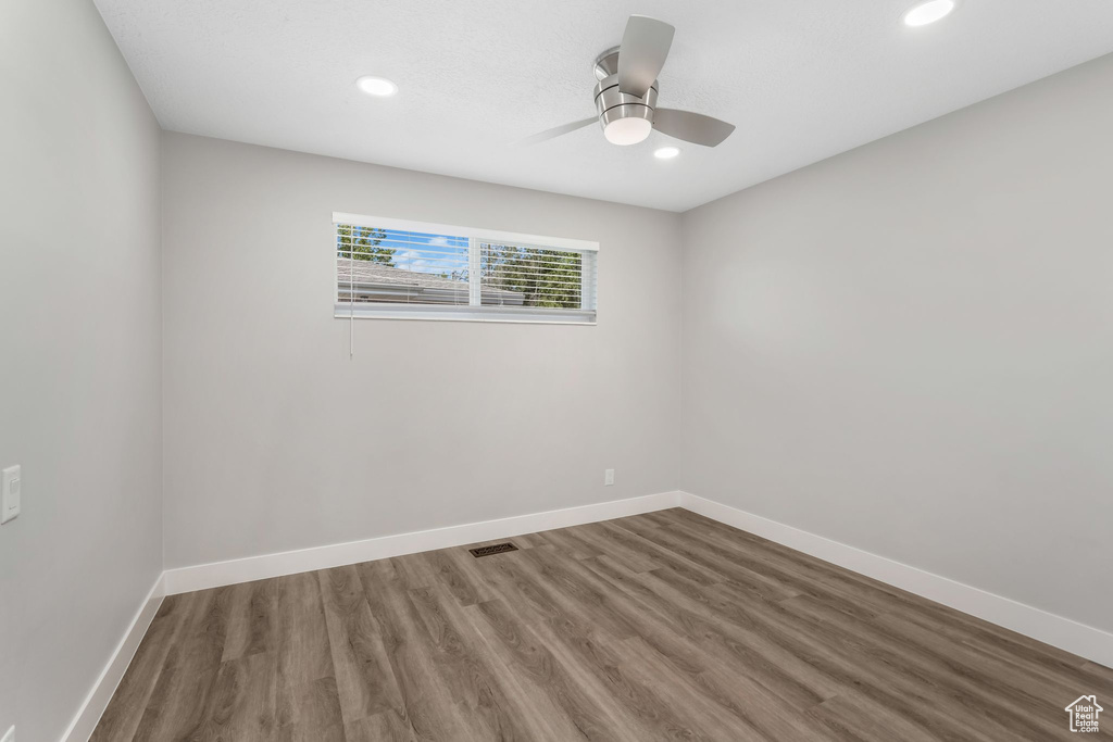 Spare room with wood finished floors, baseboards, recessed lighting, and a ceiling fan