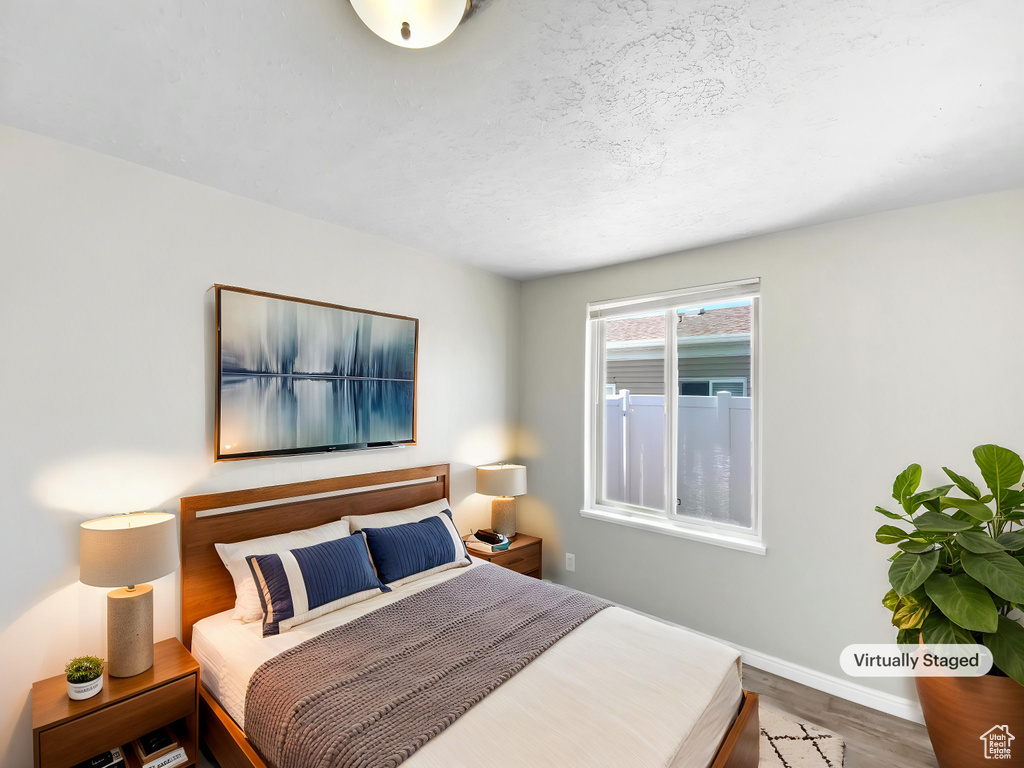 Bedroom with wood finished floors and baseboards