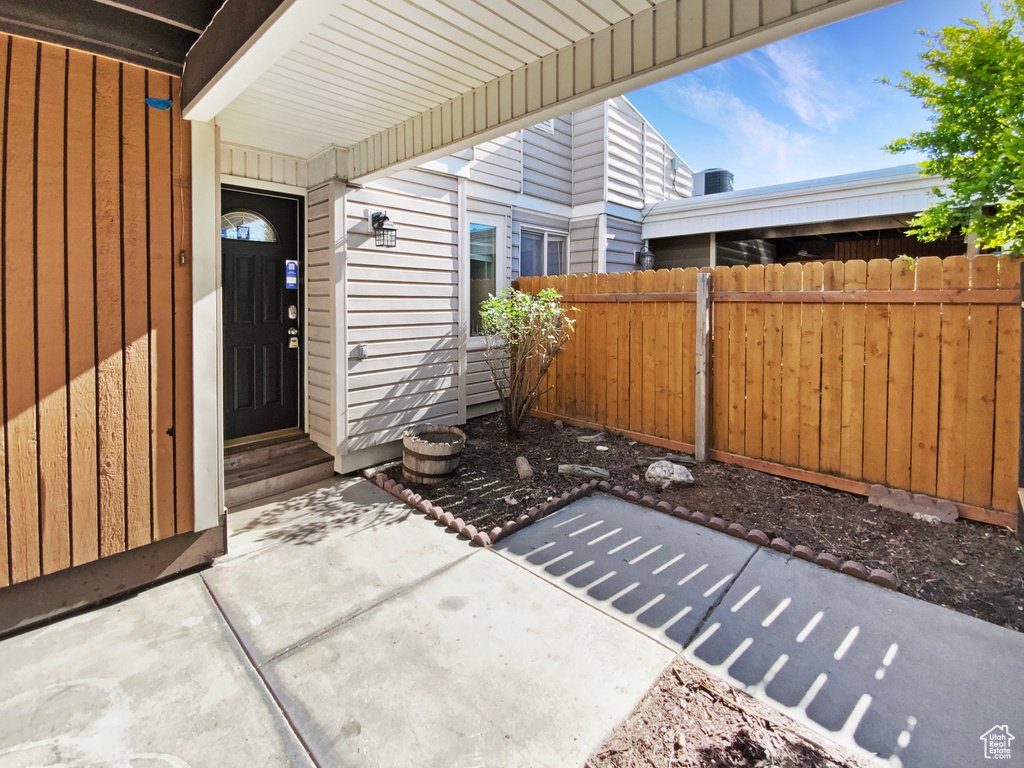 Property entrance with fence and a patio area