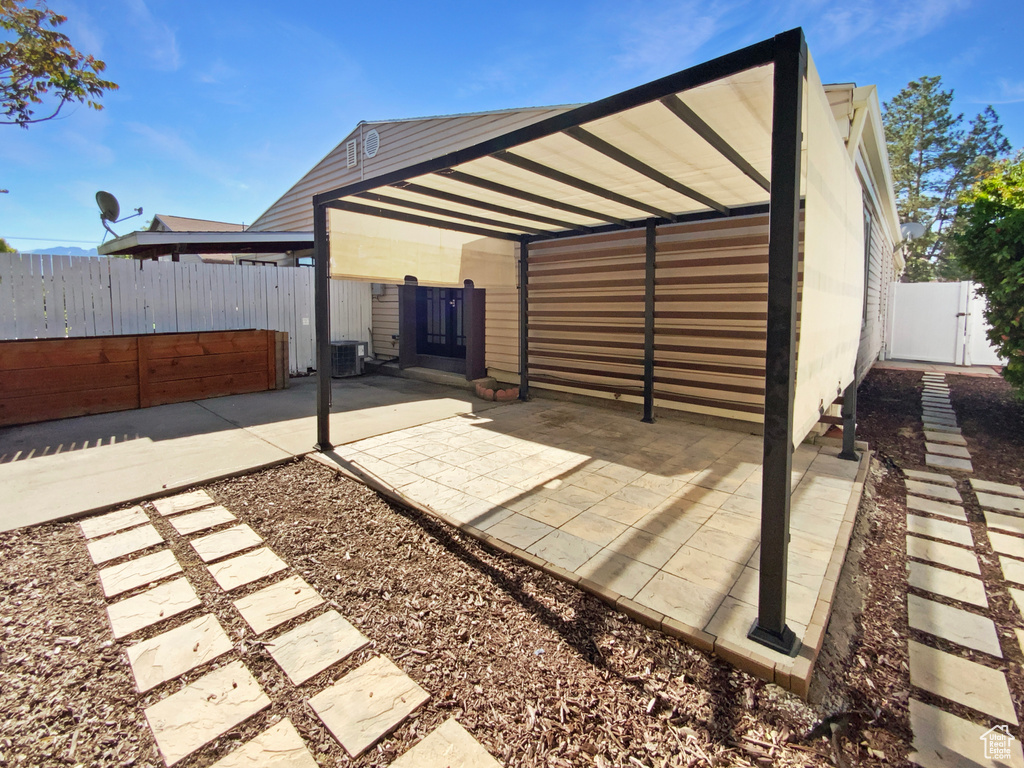 View of patio featuring a gate, fence, and central AC unit