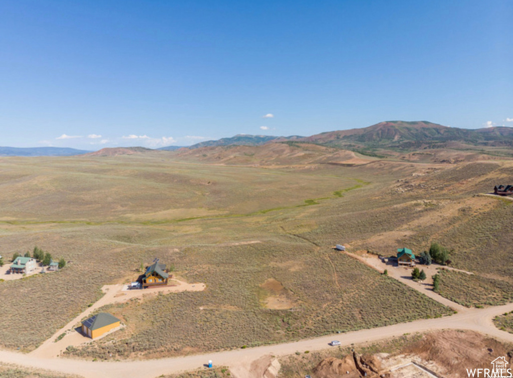 Aerial overview of property's location featuring a mountainous background and rural landscape