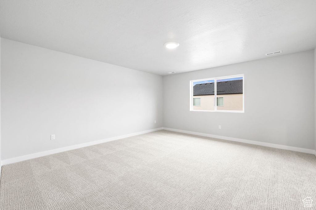 Unfurnished room featuring light colored carpet and baseboards