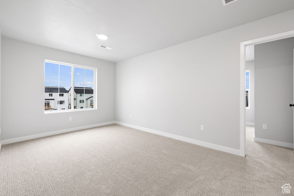 Unfurnished room with light colored carpet and baseboards