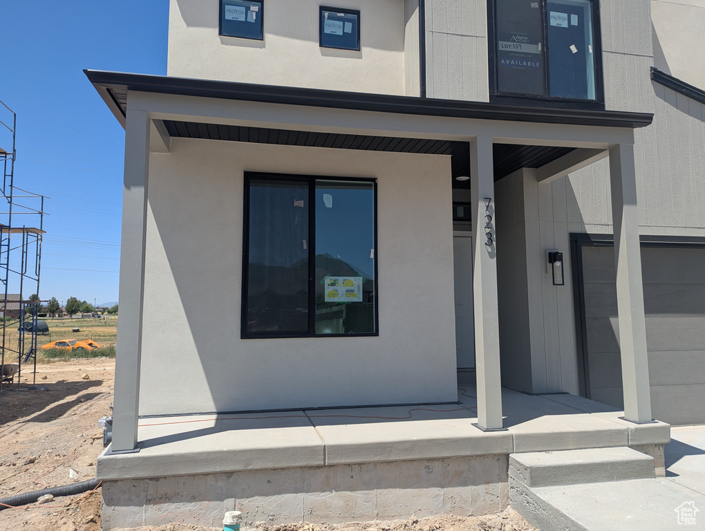 View of exterior entry featuring stucco siding and an attached garage