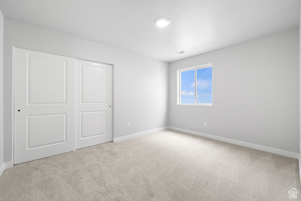 Unfurnished bedroom with carpet, baseboards, and a closet