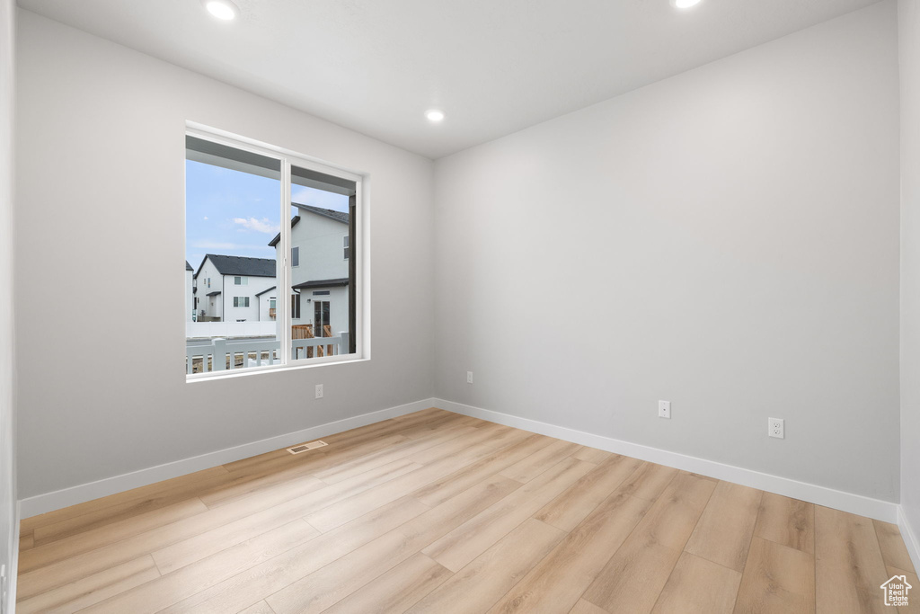 Spare room with wood finished floors, recessed lighting, and baseboards