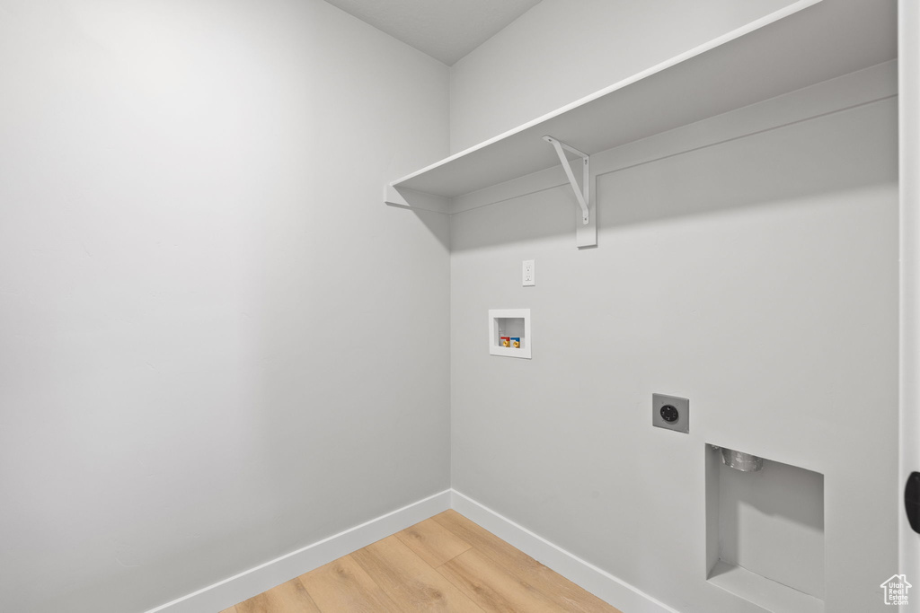 Laundry area with washer hookup, electric dryer hookup, baseboards, and light wood finished floors