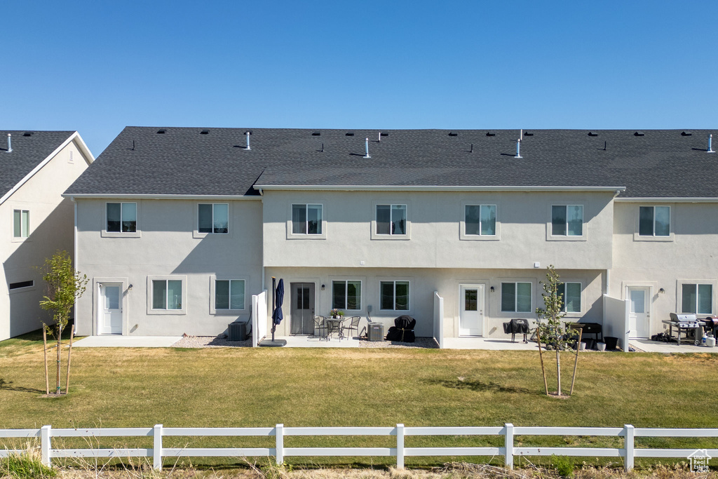 Back of property with a patio, stucco siding, and roof with shingles