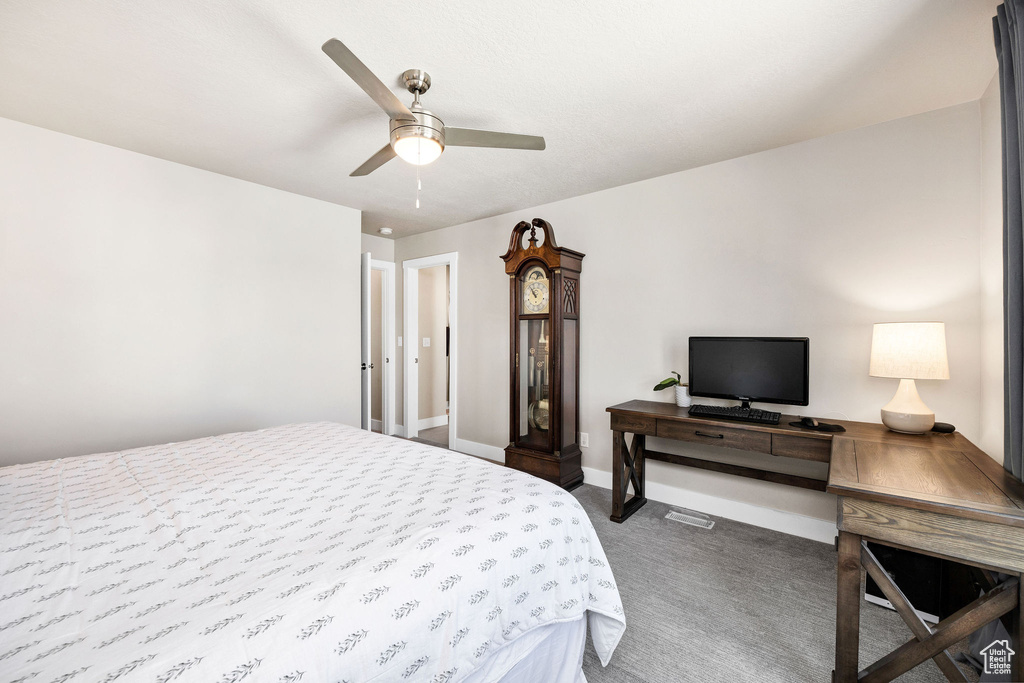 Bedroom featuring dark carpet, baseboards, and ceiling fan