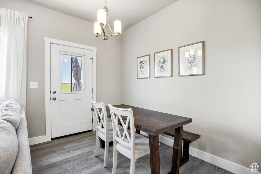 Dining area with a chandelier, light wood-style floors, and baseboards